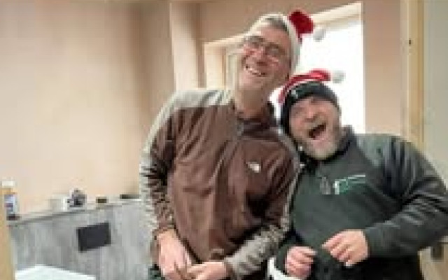 Andy and Andy share a laugh on-site, spreading festive cheer in their Santa hats during a bathroom installation.